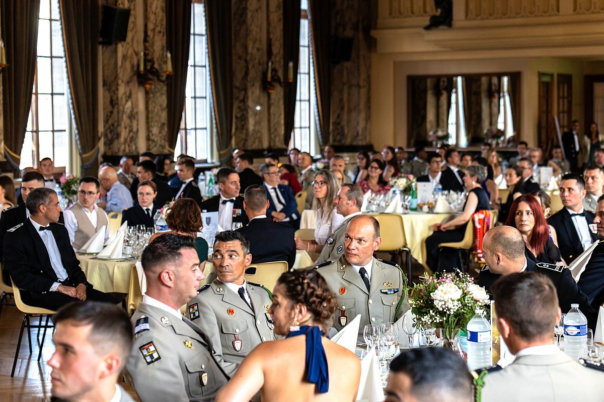 Convives et militaires en tenue d'apparat lors du dîner de gala du 5e Régiment de Dragons, salle comble dans un décor de marbre, production BLK Production