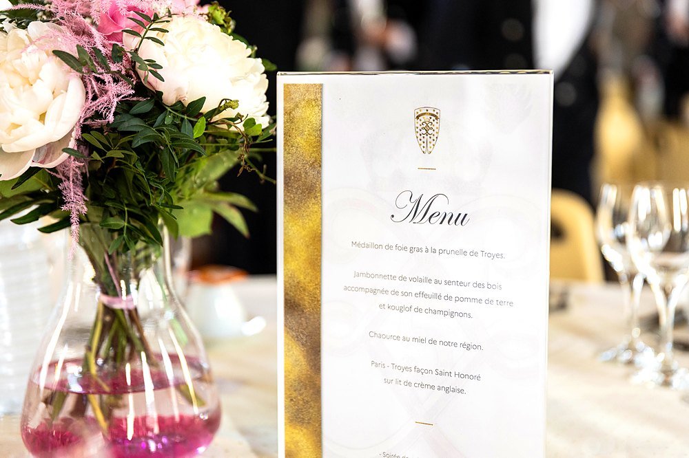 Menu gastronomique et décoration florale du dîner de gala du 5e Régiment de Dragons, table dressée avec raffinement, événement produit par BLK Production à Troyes