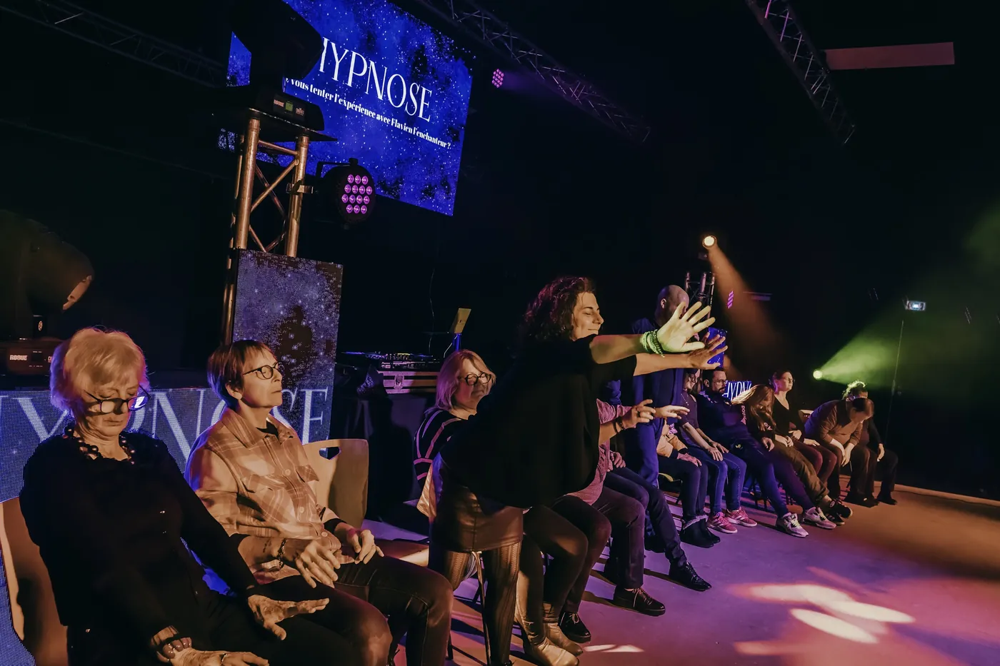Les volontaires assis sur scène, yeux fermés, pendant le spectacle d'hypnose de Flavien l'Enchanteur