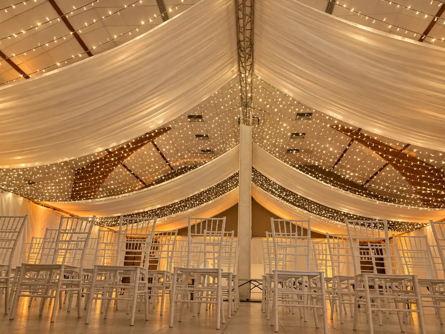 Salle habillée de drapés au plafond, guirlandes et lumière chaude
