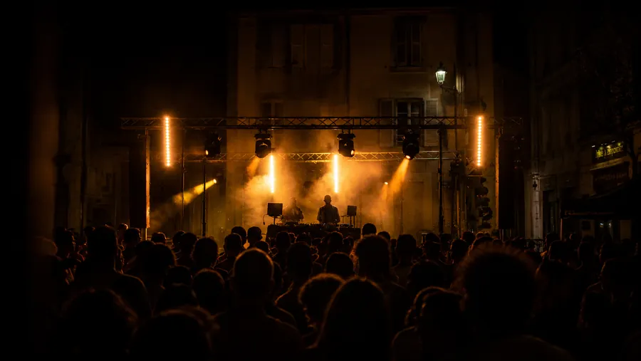 Scène extérieure sur structure aluminium, lyres et fumée, soirée DJ devant le public