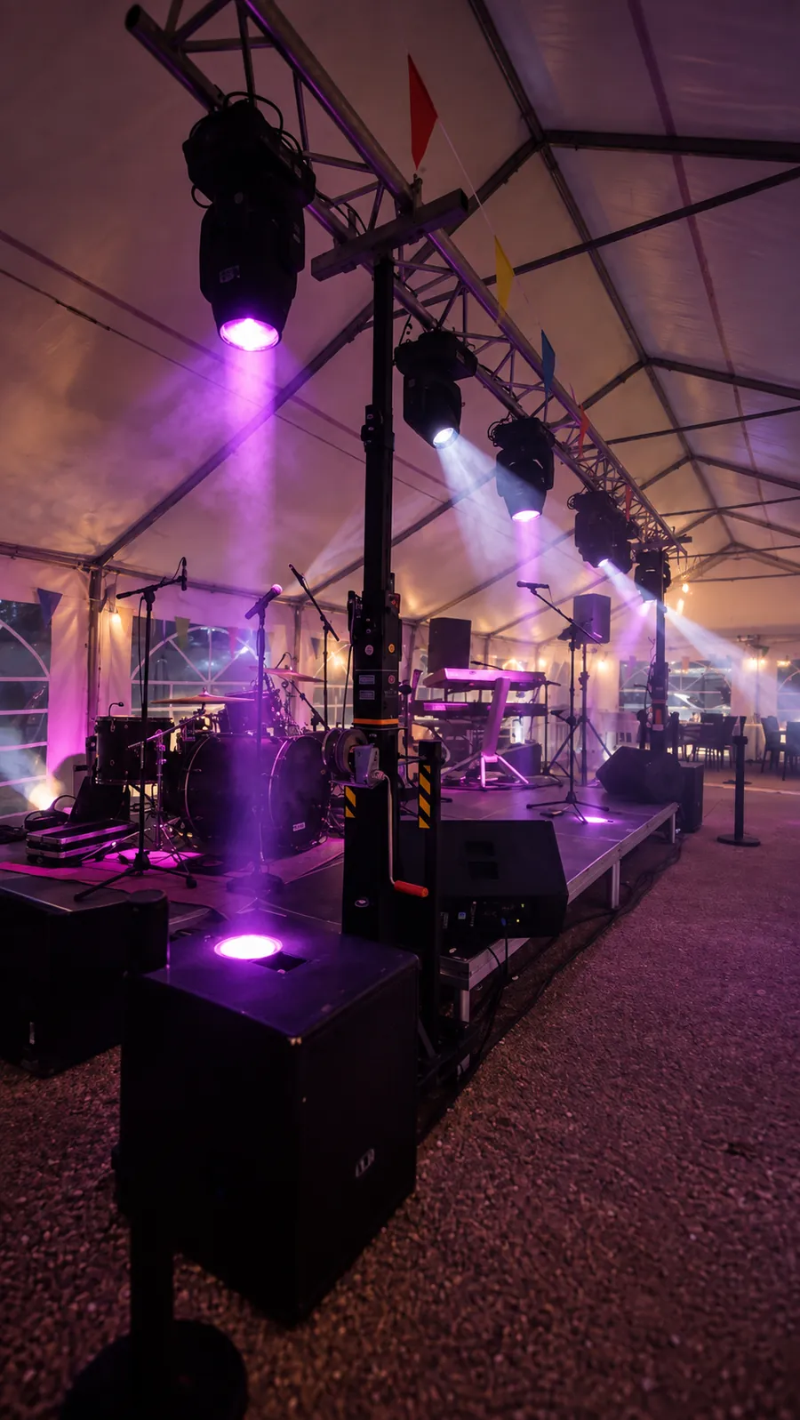 Scène BLK Production sous chapiteau, lyres sur structure, batterie et claviers prêts pour un concert
