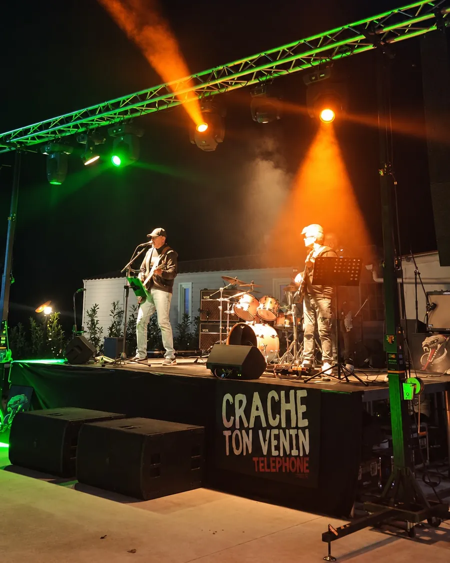 Concert de nuit de Crache ton Venin, faisceaux orange et structure éclairée en vert
